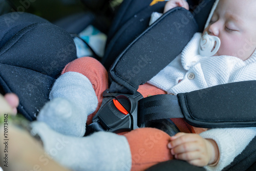 little baby sleeping in the car transport seat. child restraint system, safety harness. safety and transportation concept in babies and children