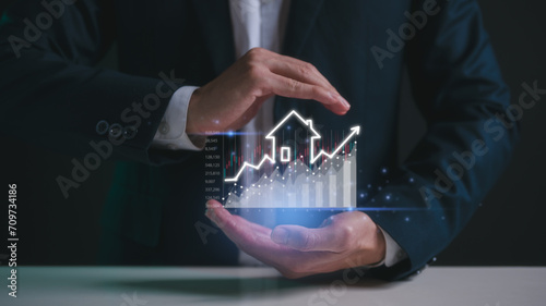 businessman hold and protecting virtual property and trading graph in real estate investment concept energy efficiency rating and property value land price, property tax photo