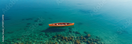 A solitary canoe floats on a clear, tranquil lake, showcasing a sense of peace and solitude in nature © AI Petr Images