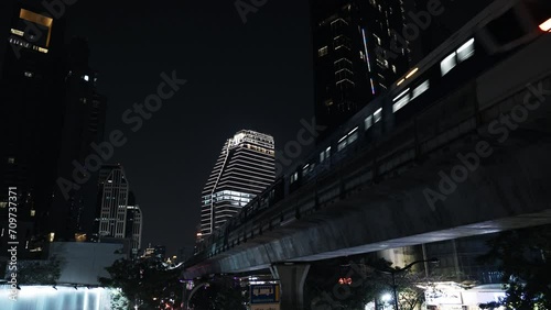 Train moving above ground between buildings, BTS skytrain city subway, modern urban view of bangkok thailand photo
