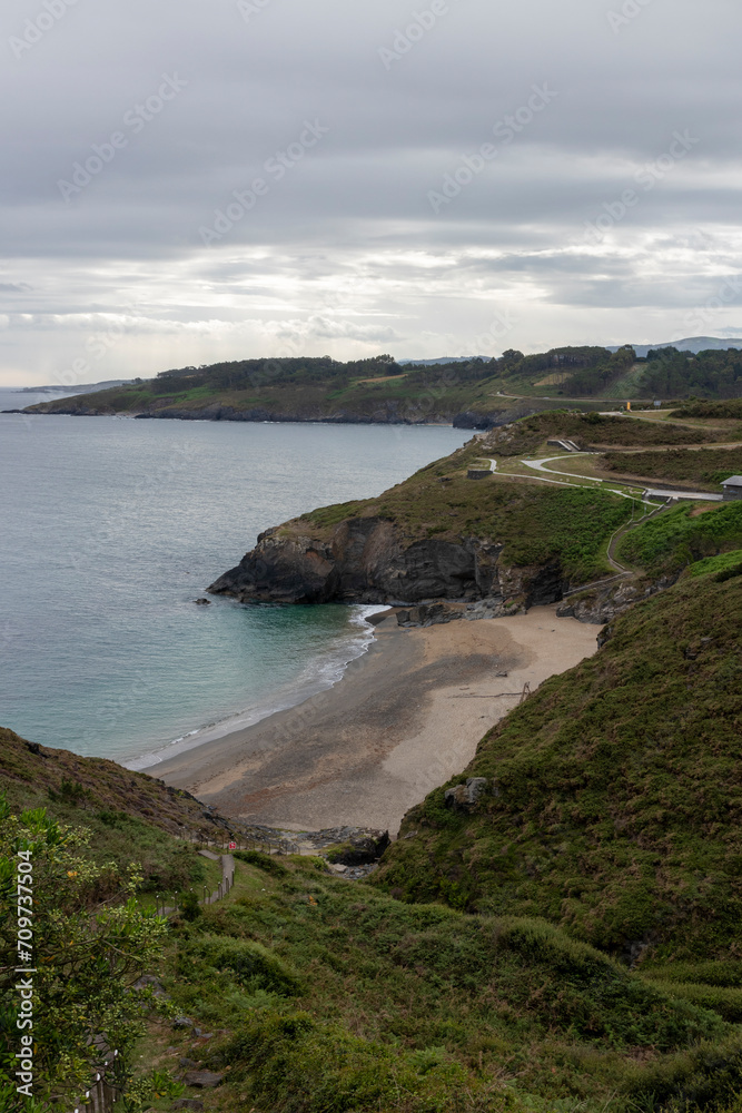 a scenic view of a secluded beach, surrounded by greenery and cliffs, under a cloudy sky a scenic view of a secluded beach, surrounded by greenery and cliffs, under a cloudy sky