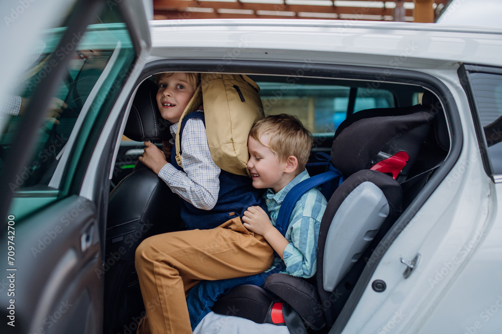 Children getting into the car, father taking them to school and kindergarten before going to work.