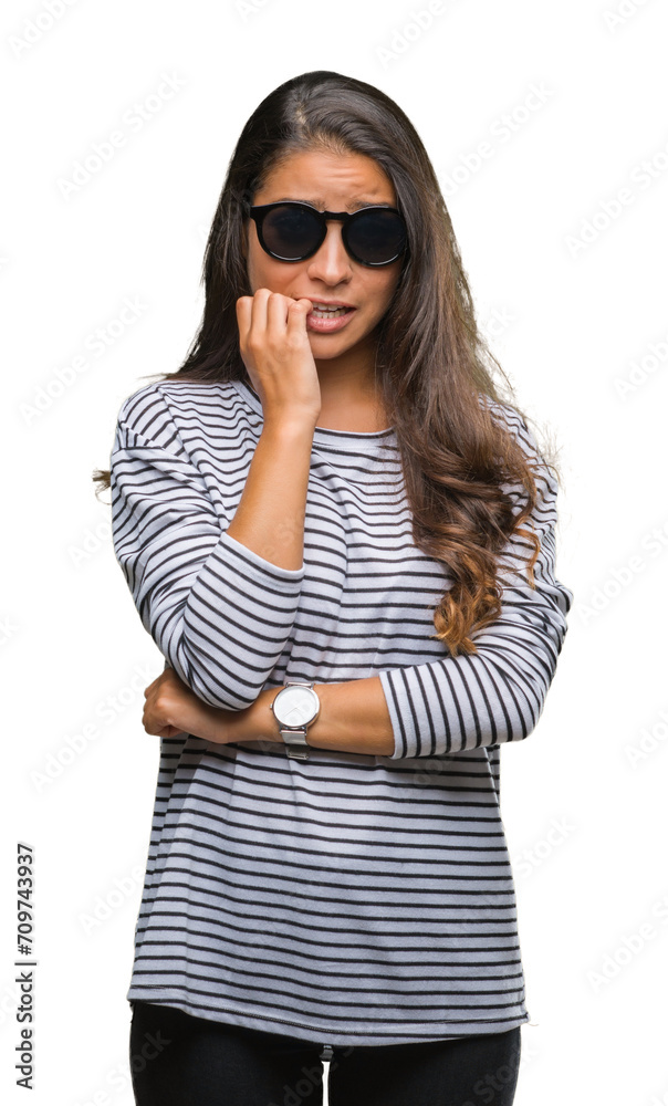 Young beautiful arab woman wearing sunglasses over isolated background looking stressed and nervous with hands on mouth biting nails. Anxiety problem. Young beautiful arab woman wearing sunglasses over isolated background looking stressed and nervous with hands on mouth biting nails. Anxiety problem.