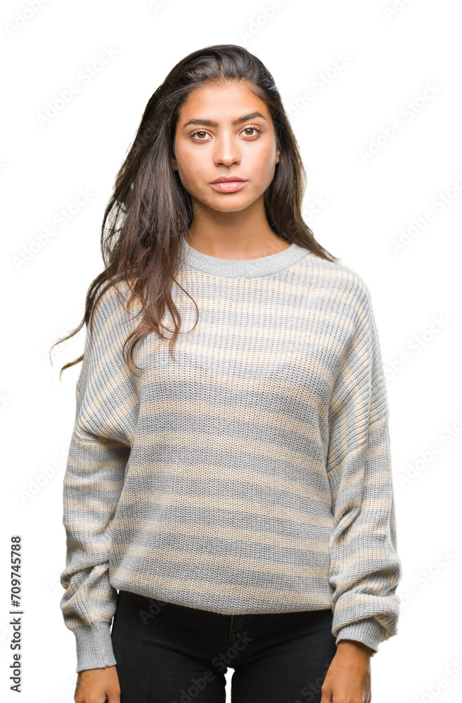 Young beautiful arab woman wearing winter sweater over isolated background with serious expression on face. Simple and natural looking at the camera. Young beautiful arab woman wearing winter sweater over isolated background with serious expression on face. Simple and natural looking at the camera.