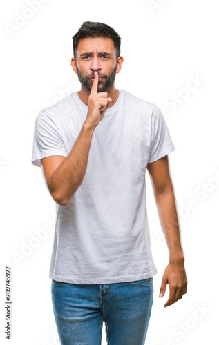 Adult hispanic man over isolated background asking to be quiet with finger on lips. Silence and secret concept.