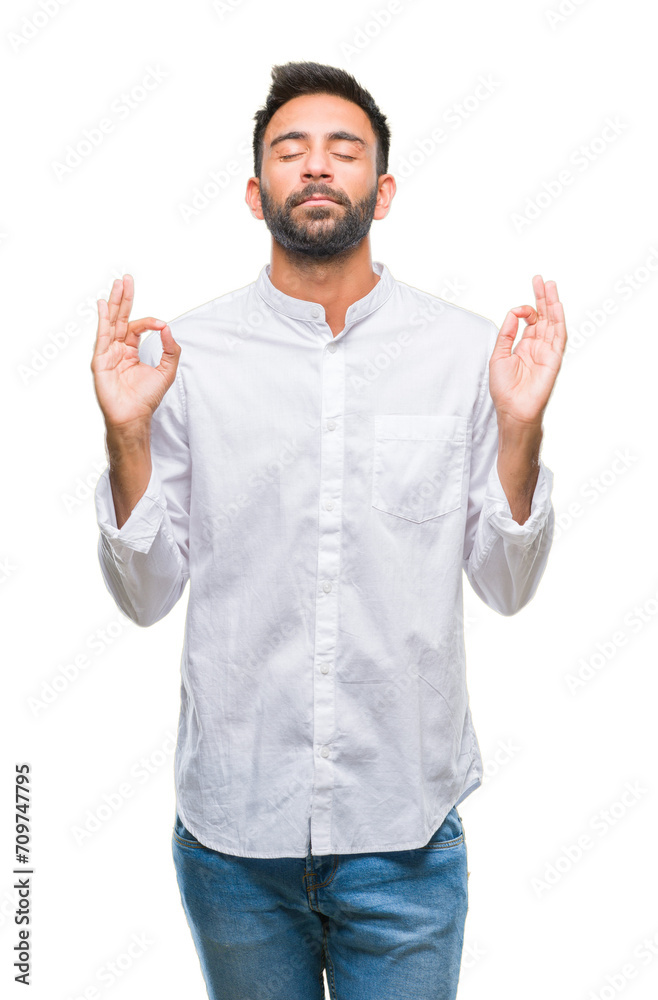 Adult hispanic man over isolated background relax and smiling with eyes closed doing meditation gesture with fingers. Yoga concept. Adult hispanic man over isolated background relax and smiling with eyes closed doing meditation gesture with fingers. Yoga concept.