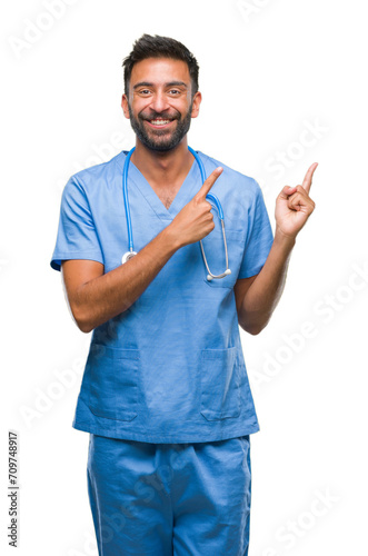 Adult hispanic doctor or surgeon man over isolated background smiling and looking at the camera pointing with two hands and fingers to the side.