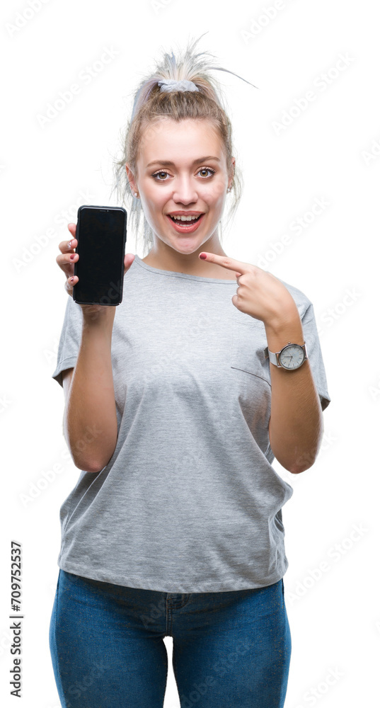 Young blonde woman showing screen of smartphone over isolated background very happy pointing with hand and finger Young blonde woman showing screen of smartphone over isolated background very happy pointing with hand and finger