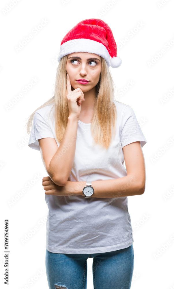 Young beautiful blonde woman christmas hat over isolated background with hand on chin thinking about question, pensive expression. Smiling with thoughtful face. Doubt concept. Young beautiful blonde woman christmas hat over isolated background with hand on chin thinking about question, pensive expression. Smiling with thoughtful face. Doubt concept.