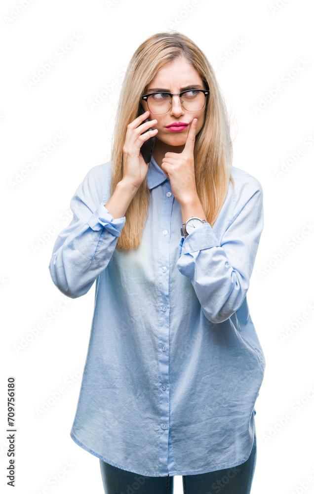 Young beautiful blonde business woman calling on smartphone over isolated background serious face thinking about question, very confused idea Young beautiful blonde business woman calling on smartphone over isolated background serious face thinking about question, very confused idea