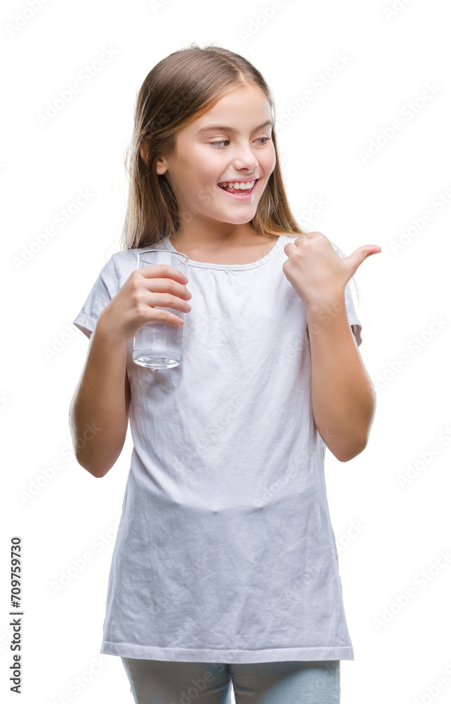 Obraz premium Young beautiful girl drinking glass of water over isolated background pointing and showing with thumb up to the side with happy face smiling