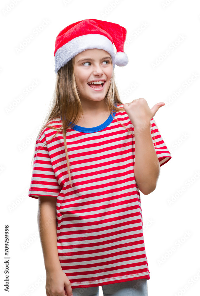 Young beautiful girl wearing christmas hat over isolated background smiling with happy face looking and pointing to the side with thumb up.