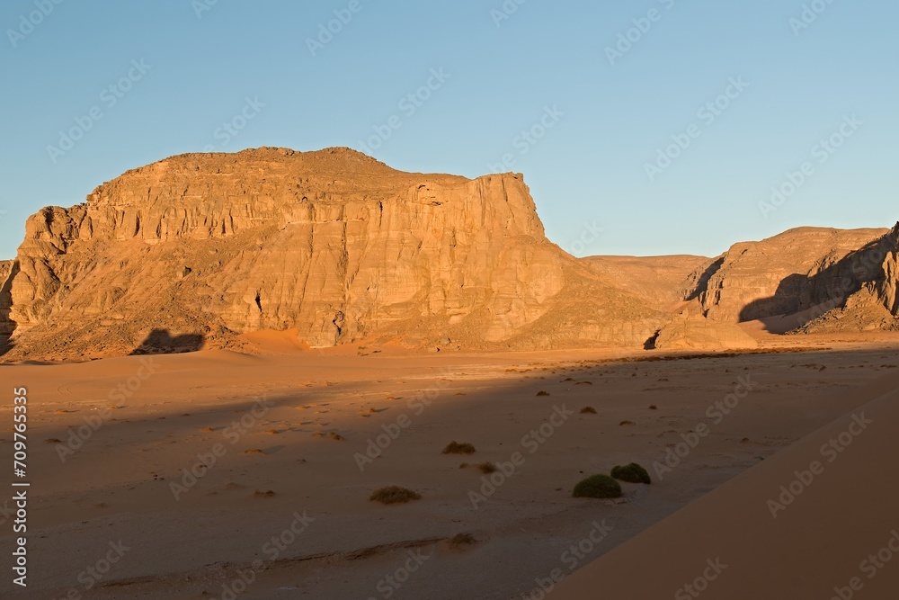 View of the rock formations Playa of Moul Naga at sunrise of the Tadrart Rouge rocky mountain range in Tassili n Ajjer National Park. Sahara desert, Algeria, Africa.
