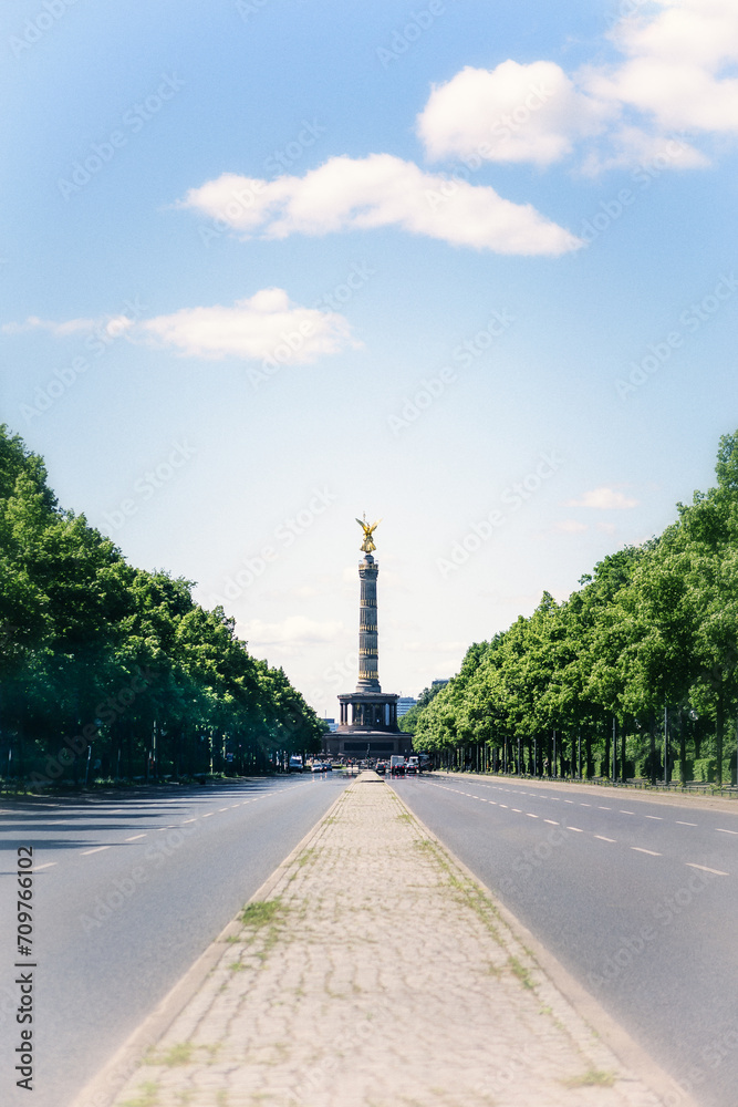 Victory Column in Berlin lined with green trees. Germany