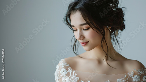 bride standing . she is wearing a beautiful dress and she is smiling. on a gray background, close-up, with empty copy space, wedding advertising photo