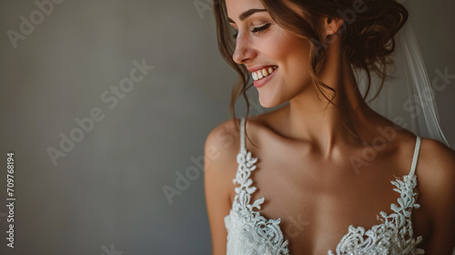 bride standing . she is wearing a beautiful dress and she is smiling. on a gray background, close-up, with empty copy space, wedding advertising photo
