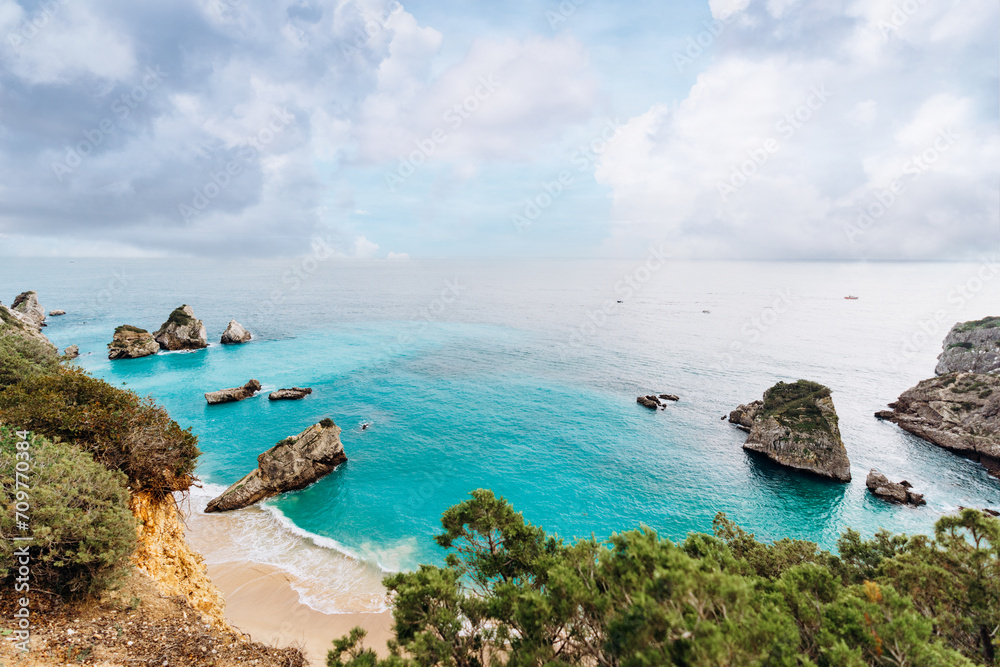 Obraz premium Secret beach in Sesimbra with high cliffs and sky blue water - Praia do Ribeiro do Cavalo