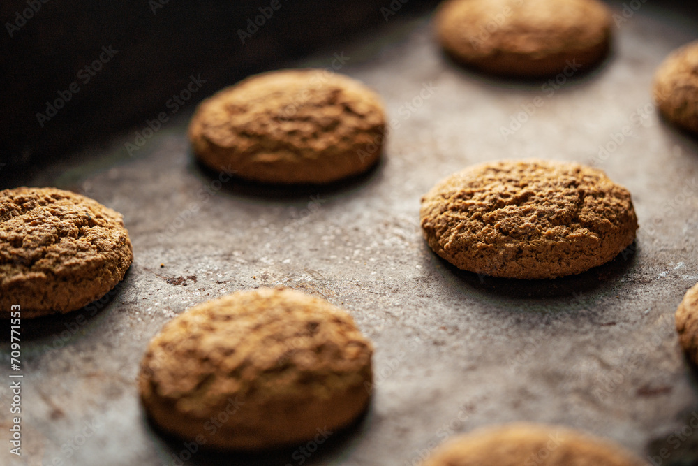 Oatmeal cookies on baking sheet. Fresh sweet pastries for tea. Homemade oatmeal sweets.