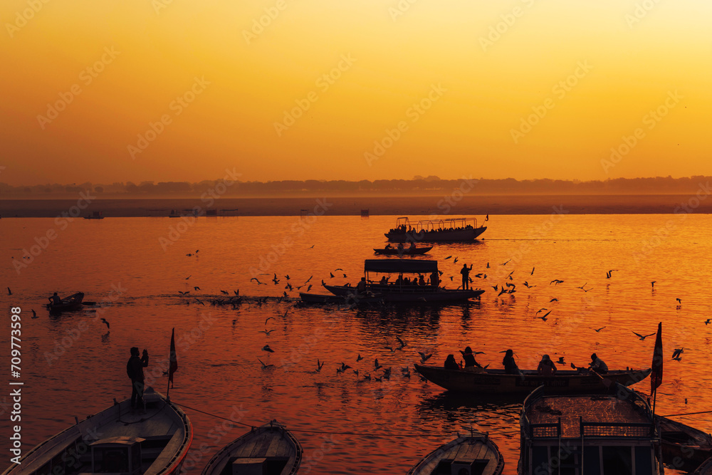Birds and Boats during dawn on sacred river Ganges in Varanasi, India