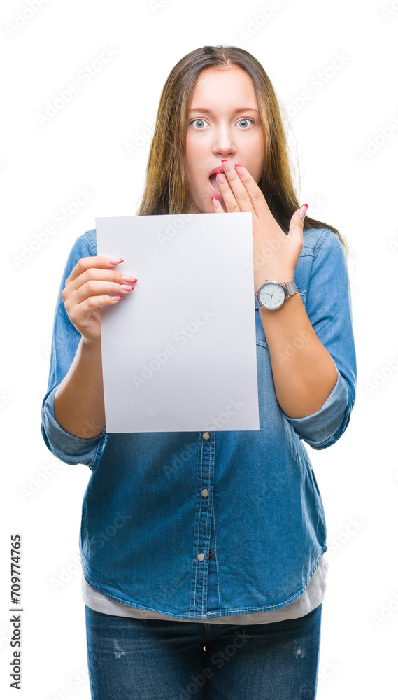 Young caucasian woman holding blank paper sheet over isolated background cover mouth with hand shocked with shame for mistake, expression of fear, scared in silence, secret concept Young caucasian woman holding blank paper sheet over isolated background cover mouth with hand shocked with shame for mistake, expression of fear, scared in silence, secret concept