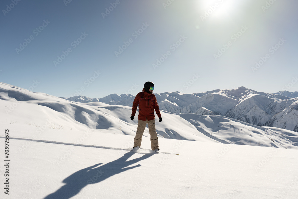 snowboarder freerider riding on an unprepared snow field on board in high mountains