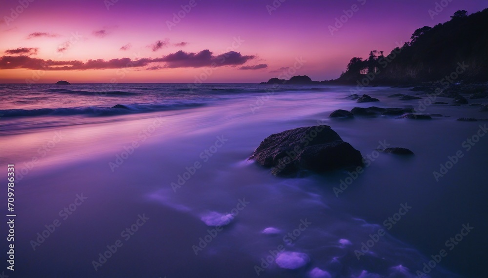 Obraz premium A Secluded Beach with Bioluminescent Waves at Night, the shoreline aglow with ethereal blue light
