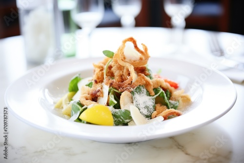 crispy calamari atop caesar salad with shaved parmesan