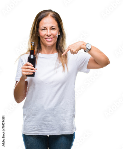Middle age hispanic woman drinking beer over isolated background with surprise face pointing finger to himself