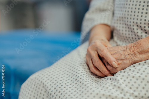 Close up of hands of senior patient on examination table in the hospital. Concept of fear and anxiety about health problems in elderly people. photo