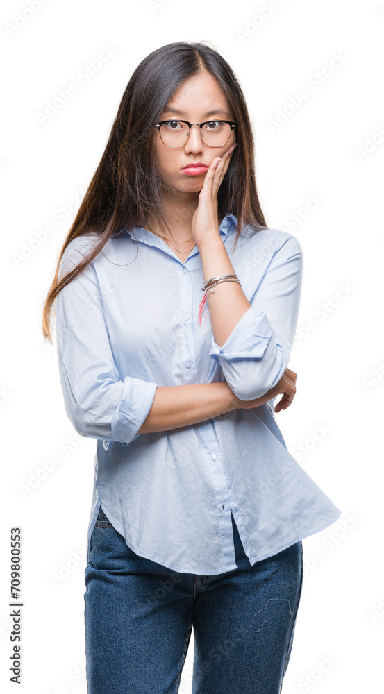 Young asian business woman wearing glasses over isolated background thinking looking tired and bored with depression problems with crossed arms.
