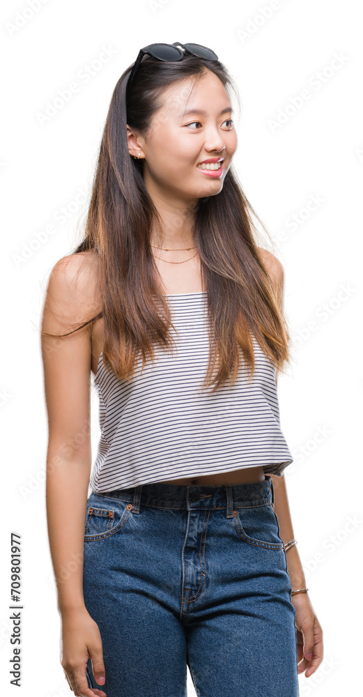 Obraz premium Young asian woman wearing sunglasses over isolated background looking away to side with smile on face, natural expression. Laughing confident.