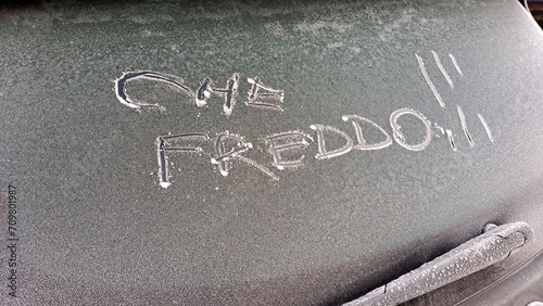 Che freddo ! scritta italiano sul lunotto posteriore di un'auto coperta da ghiaccio. photo
