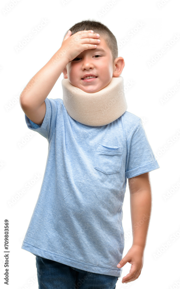 Dark haired little child injured wearing neck collar stressed with hand on head, shocked with shame and surprise face, angry and frustrated. Fear and upset for mistake.