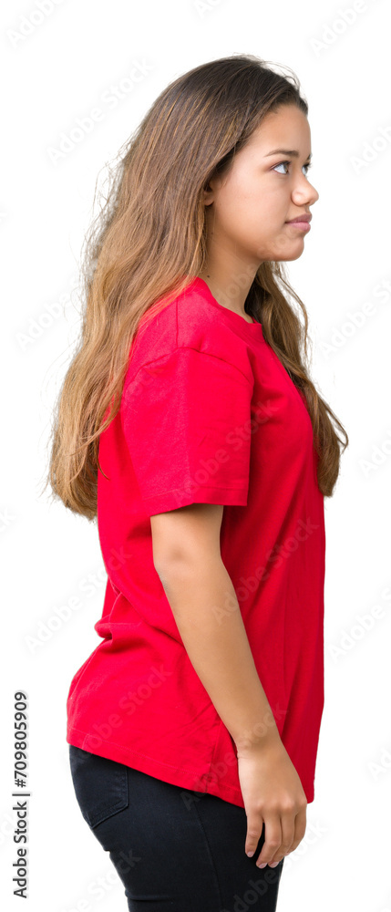 Young beautiful brunette woman wearing red t-shirt over isolated background looking to side, relax profile pose with natural face with confident smile. Young beautiful brunette woman wearing red t-shirt over isolated background looking to side, relax profile pose with natural face with confident smile.