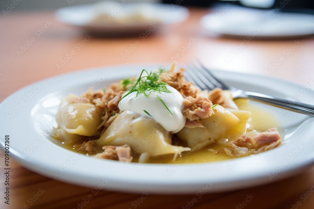 plate of perogies with sauerkraut filling, sour cream dollop plate of perogies with sauerkraut filling, sour cream dollop