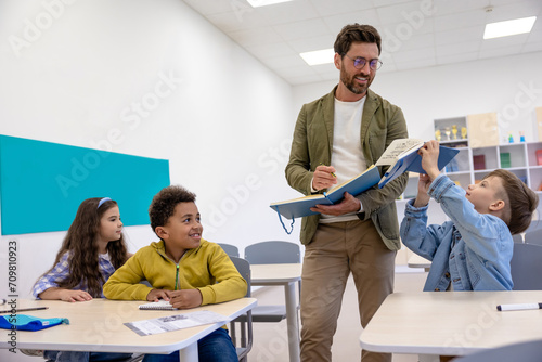 Man teacher in classroom with little students.