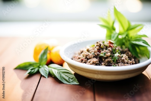 tapenade in a clay dish with a side of fresh basil