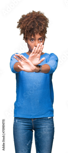 Beautiful young african american woman over isolated background Rejection expression crossing arms and palms doing negative sign, angry face