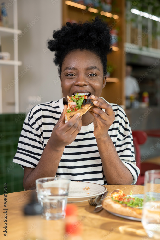 Cute dark-skinned young woman enjoying pizza Cute dark-skinned young woman enjoying pizza