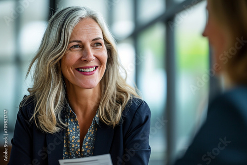 Confident Mature Businesswoman in Corporate Setting Engaging in Professional Consultation, Holding CV with a Pleasant Demeanor, Legal Advisor at Work, Employment Expert Discussing Career Opportunities photo