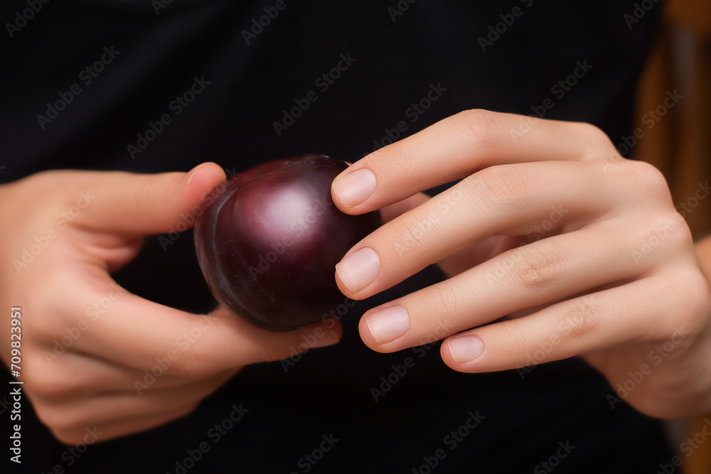 Female with ripe plum in hands close up. Female with ripe plum in hands close up.