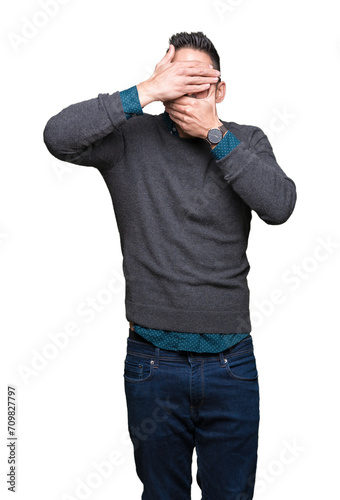 Young handsome man wearing glasses over isolated background Covering eyes and mouth with hands, surprised and shocked. Hiding emotion