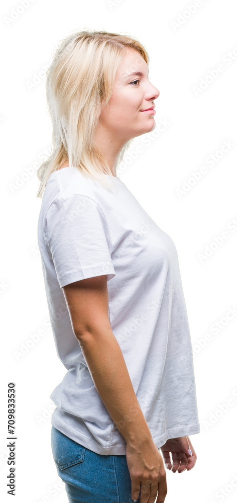 Young beautiful blonde woman wearing white t-shirt over isolated background looking to side, relax profile pose with natural face with confident smile. Young beautiful blonde woman wearing white t-shirt over isolated background looking to side, relax profile pose with natural face with confident smile.