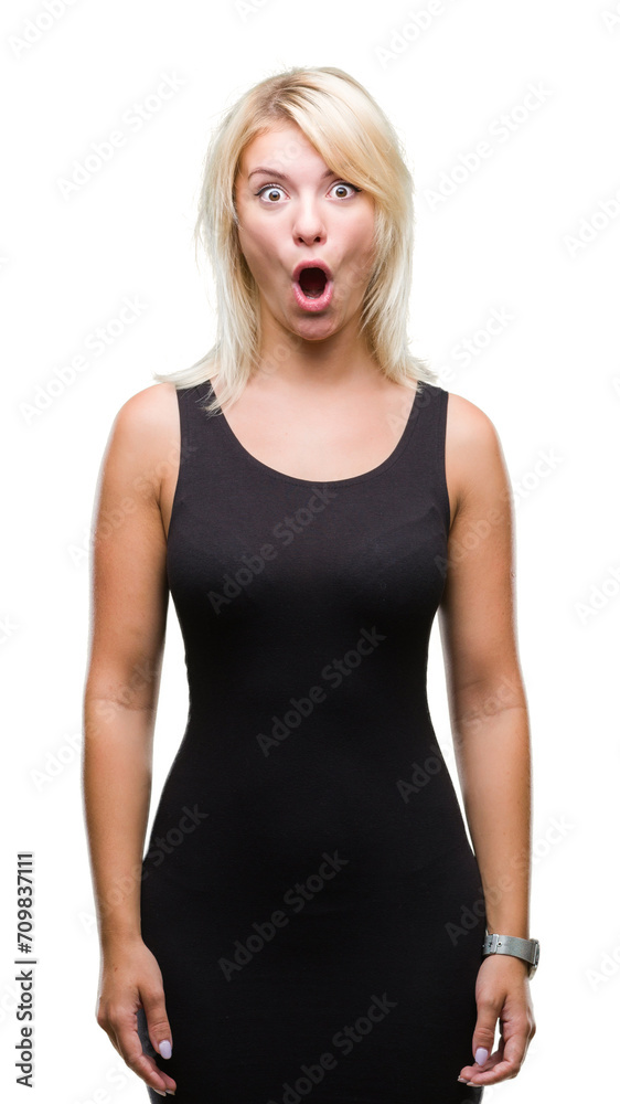 Young beautiful blonde attractive woman wearing elegant dress over isolated background afraid and shocked with surprise expression, fear and excited face. Young beautiful blonde attractive woman wearing elegant dress over isolated background afraid and shocked with surprise expression, fear and excited face.