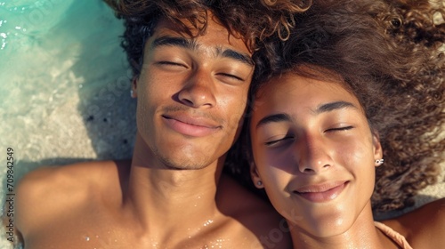selfie portrait of an mixed heterosexual couple, laying on the sandy beach together sunbathing, © Marina
