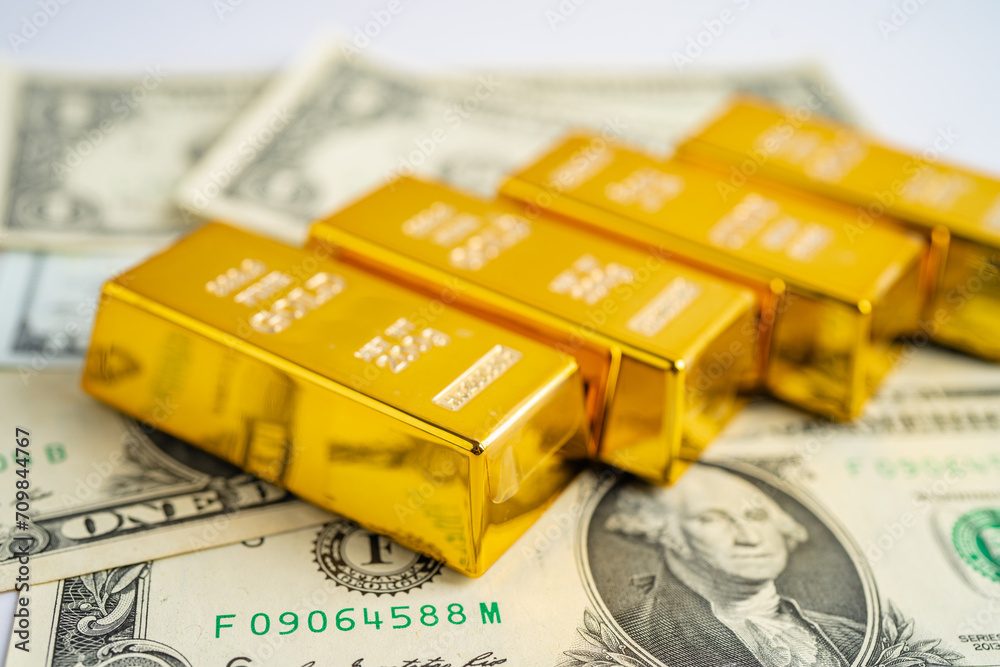 Gold bar on US dollar banknotes money and graph, economy finance exchange trade investment concept. Gold bar on US dollar banknotes money and graph, economy finance exchange trade investment concept.