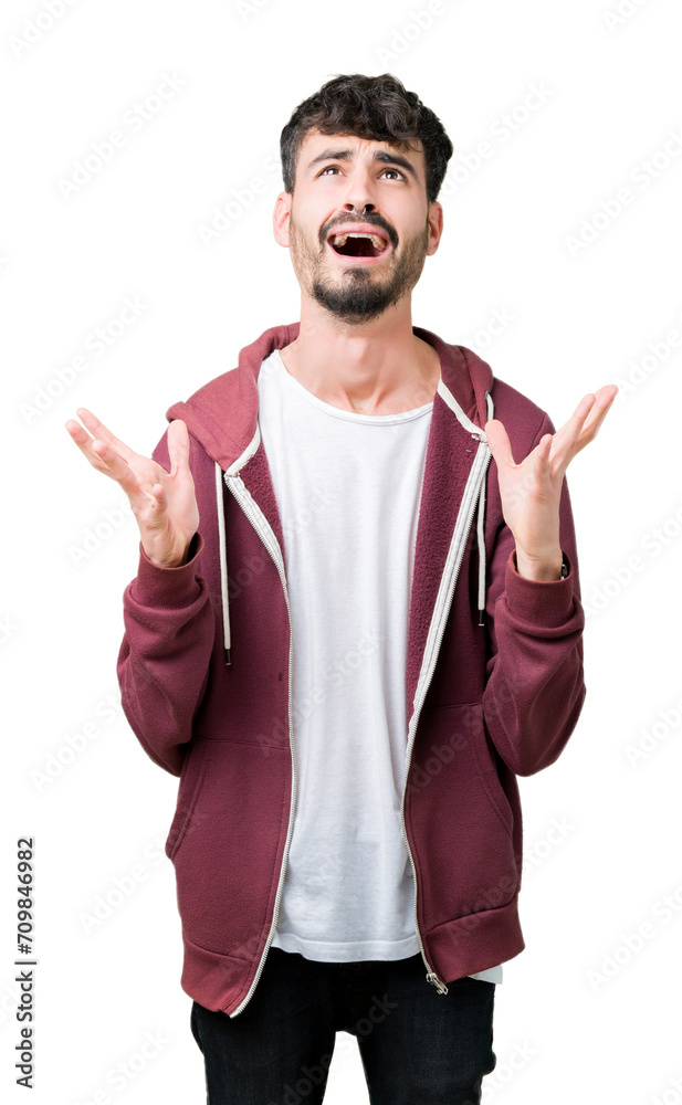 Fototapeta premium Young handsome man over isolated background crazy and mad shouting and yelling with aggressive expression and arms raised. Frustration concept.