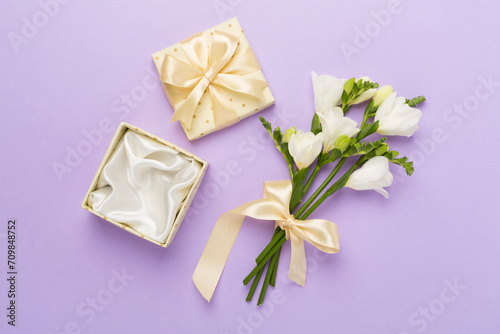 Open gift box, with fresia flower color background, top view