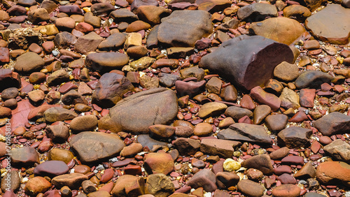 Full frame close-up texture pattern of colorful pink beach pebbles. Pink Stone Beach, Chanthaburi, Thailand. Pink stone (Arkose) near the beach, Waves hit the pink stone, Pink stone viewpoint. photo