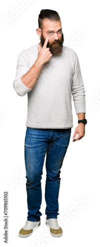 Young blond man wearing casual sweater Pointing to the eye watching you gesture, suspicious expression © Krakenimages.com